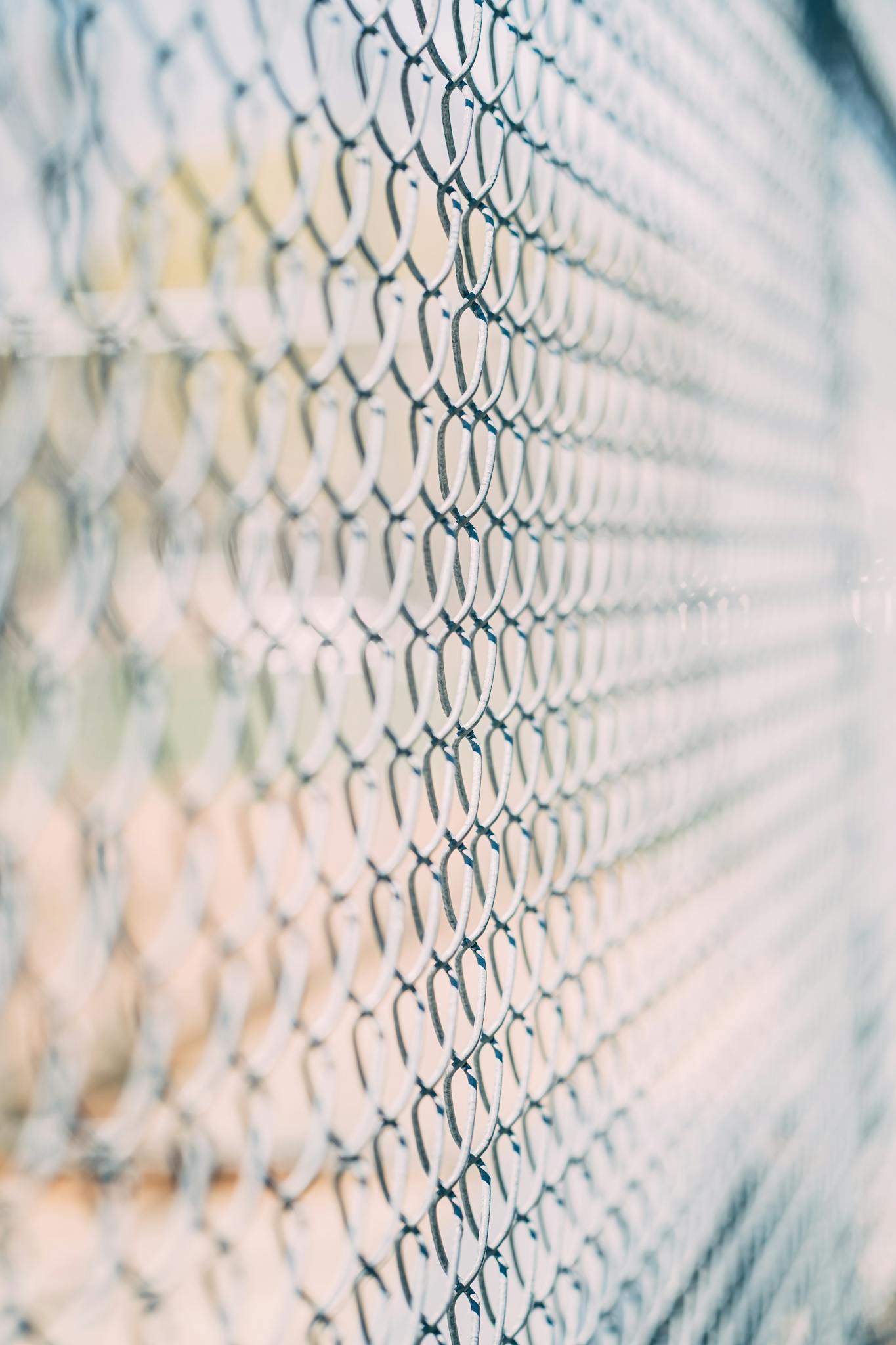 Abstract view of a chain link fence with a blurred, artistic aesthetic and soft focus.